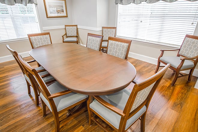 A spacious dining area featuring a wooden table and matching chairs, ideal for meetings or family gatherings.