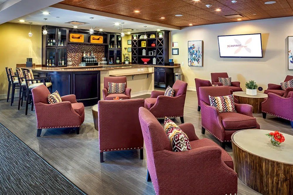 A cozy lounge area featuring comfortable red armchairs and a well-stocked bar.