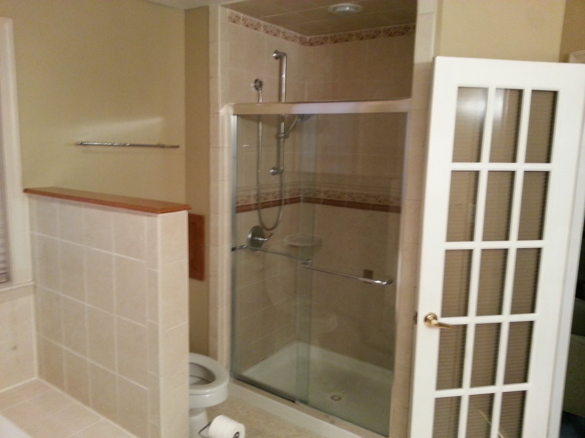 A bathroom featuring a glass-enclosed shower and a nearby toilet.