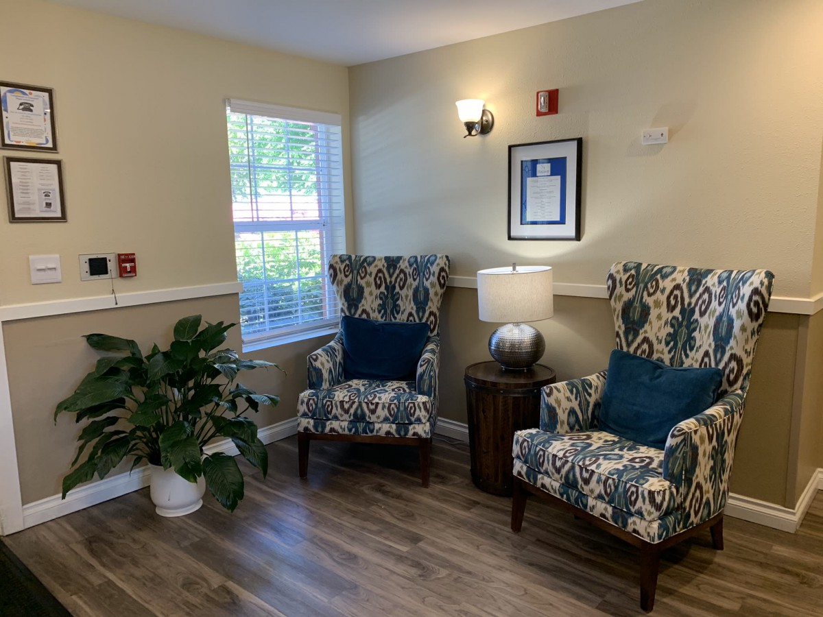 A cozy sitting area with patterned chairs, a lamp, and decorative elements.