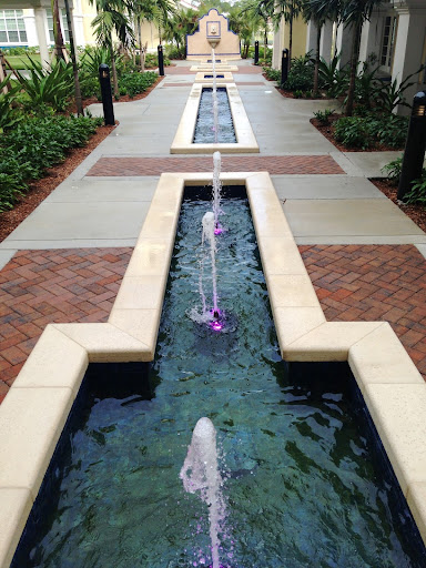 A serene outdoor setting featuring a modern water fountain along a pathway.