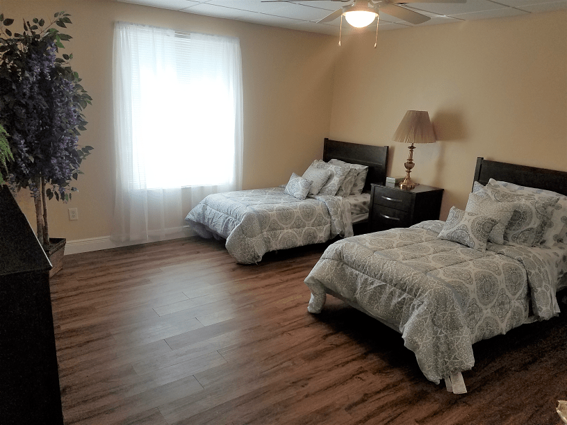A cozy bedroom with two twin beds, a nightstand, and soft lighting.
