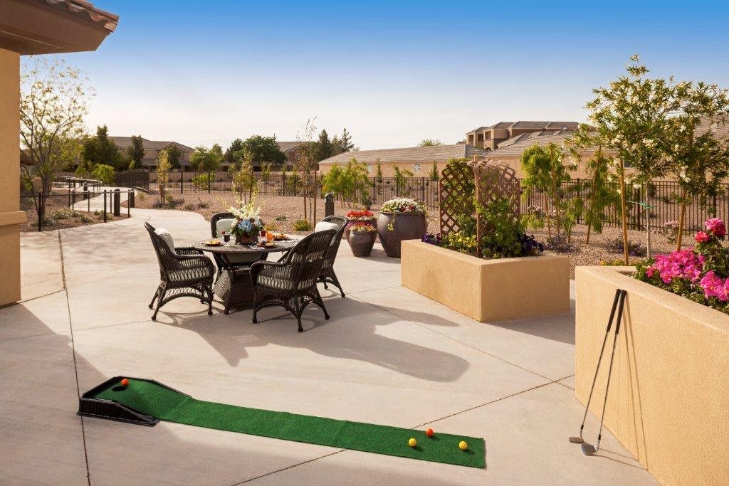 A sunny outdoor patio with a dining set and a small golf putting area.