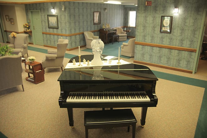 A grand piano in a cozy room with comfortable seating and elegant decor.