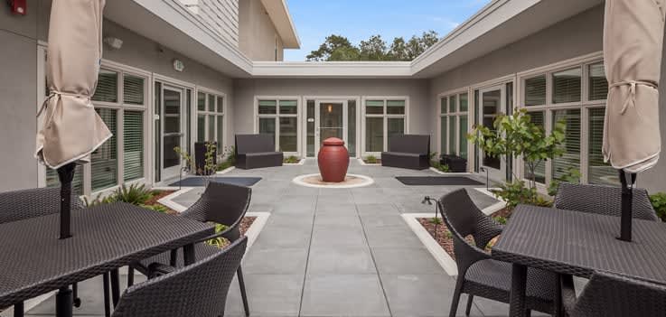 A modern courtyard with outdoor seating and a central red vase.