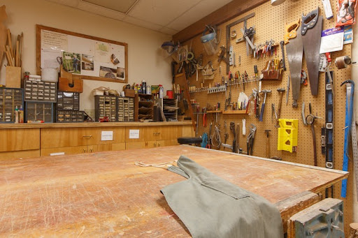 A well-organized woodworking workshop featuring various hand tools and a spacious workbench.