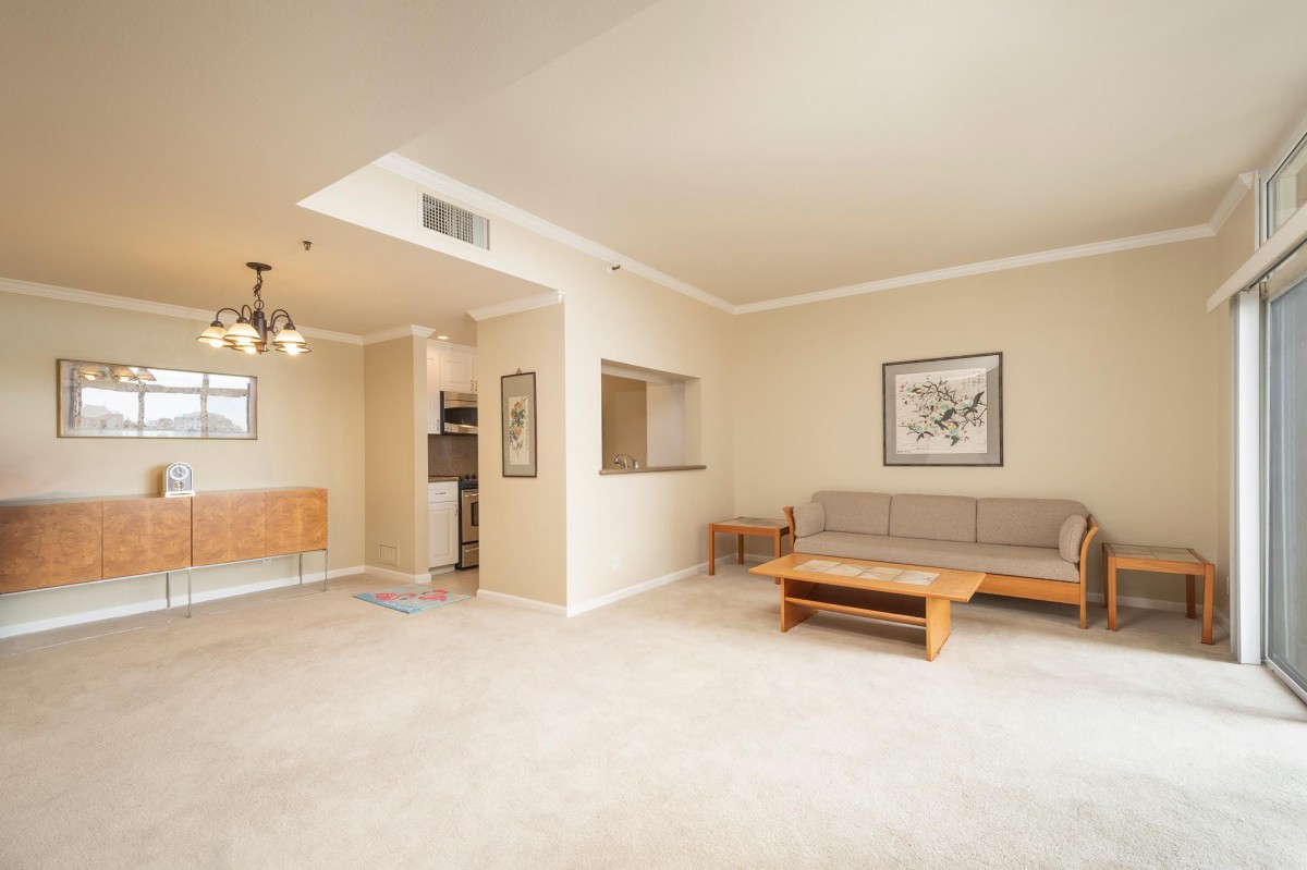 A minimalist living room with a sofa, coffee table, and neutral decor.