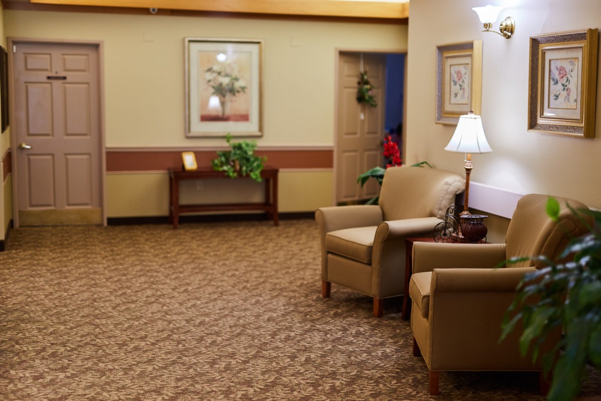 A cozy waiting area with chairs, a lamp, and decorative elements.