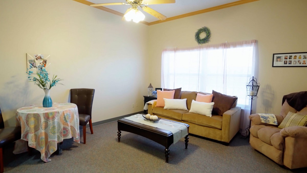 A cozy living room with a sofa, coffee table, and dining area.