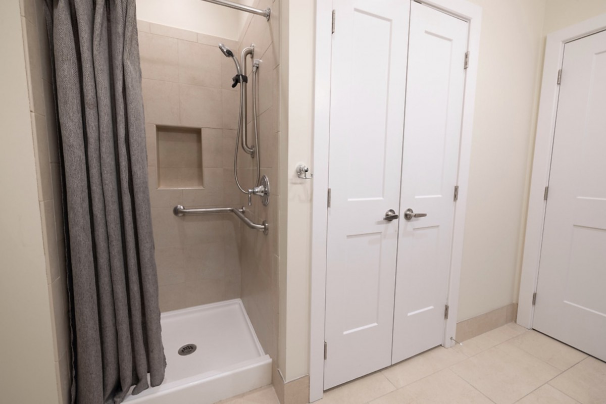 Modern bathroom with a walk-in shower and double doors.