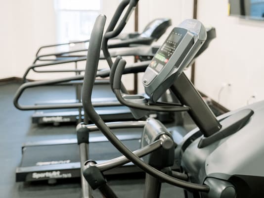 A row of treadmills in a gym, ready for a workout session.