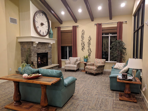 A cozy living room featuring comfortable seating, a stylish fireplace, and decorative elements.