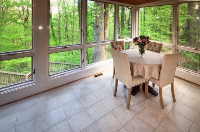 A cozy dining space with a scenic forest view through large windows.