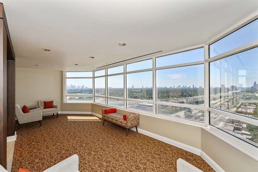 A modern room with large windows offering a cityscape view.