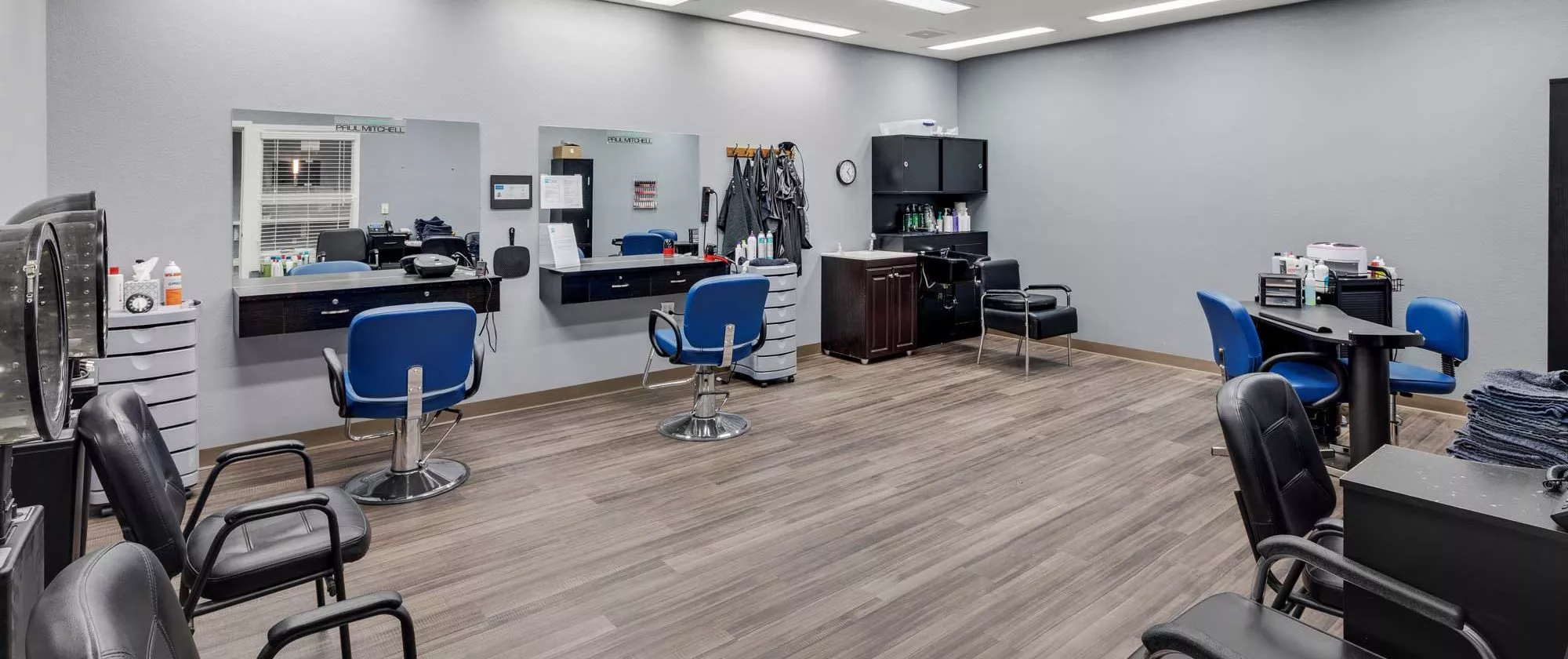 A modern barbershop interior with chairs and mirrors.