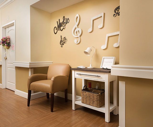 A cozy corner with musical wall decor featuring notes and symbols, complemented by a comfortable armchair and a side table.