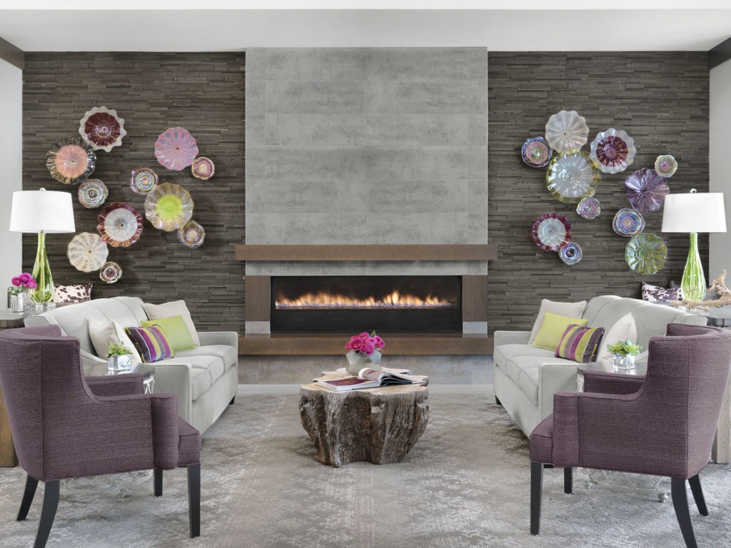A modern living room with a central fireplace, featuring decorative wall plates and stylish seating arrangements.