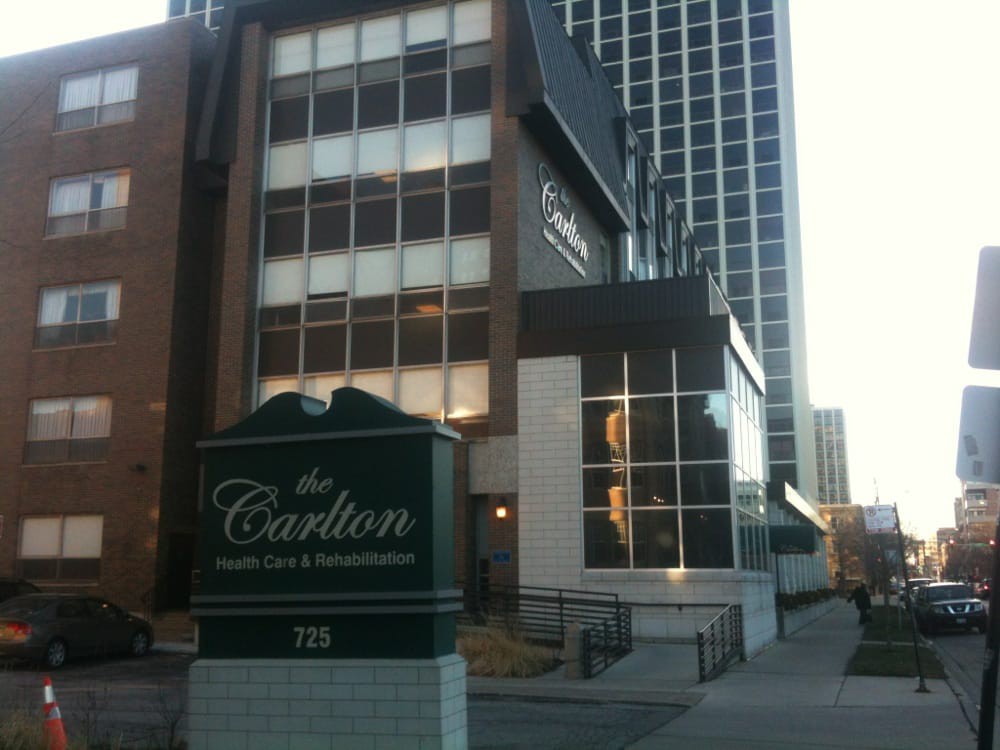 A view of an urban building with signage in front, featuring modern architectural design.