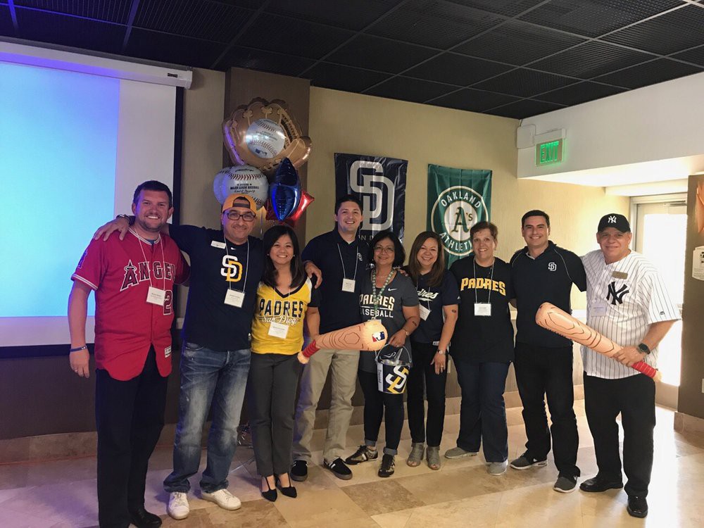 A group of people wearing sports jerseys gather for a team event indoors.