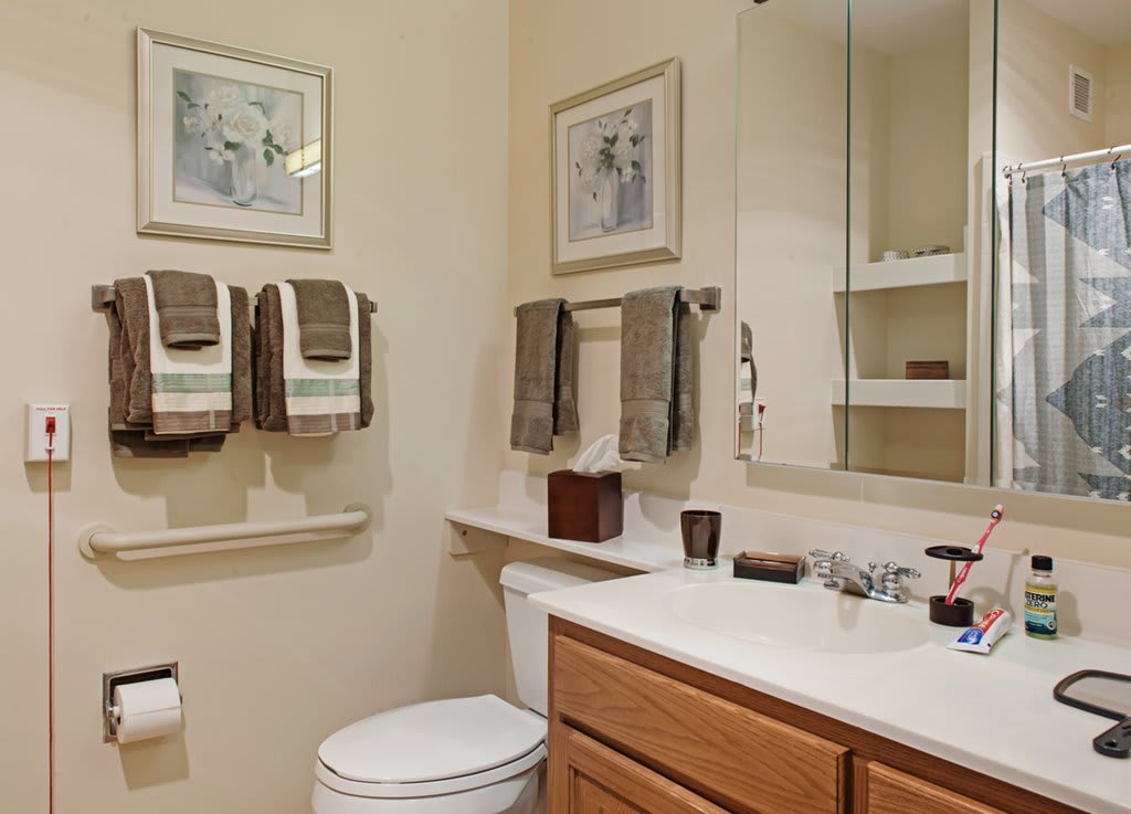 A neatly organized bathroom with towels, a mirror, and a sink.