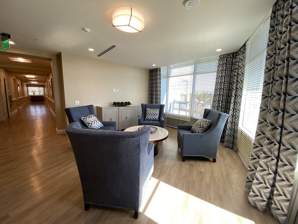 A cozy living room with modern furniture and large windows allowing natural light to fill the space.