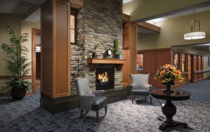 A cozy lobby area featuring a stone fireplace and elegant seating.