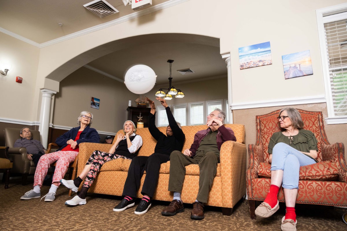 A group of seniors playing a ball game in a cozy living room setting.
