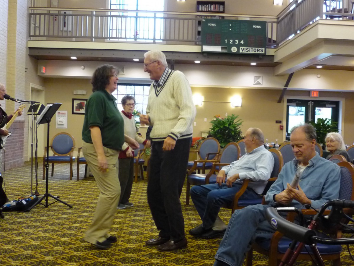 A group of seniors enjoying dancing in a community center.