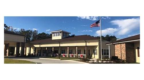 A well-designed community center with an American flag waving in front under a clear blue sky.