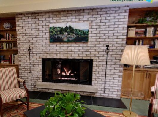 Cozy living room with a brick fireplace and decorative elements.