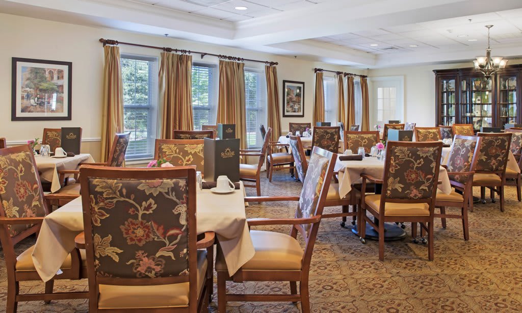 A well-decorated dining area with arranged tables and chairs, ready for guests.