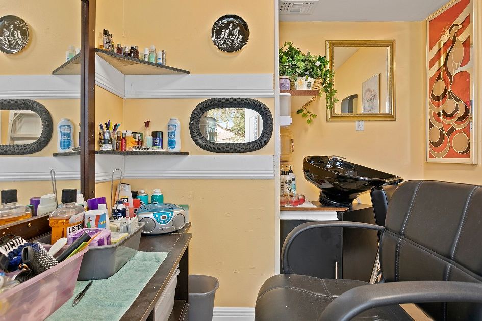 A cozy hair salon interior with styling chairs and shelves stocked with beauty products.