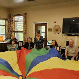 Participants engage in a lively group activity using a colorful parachute.
