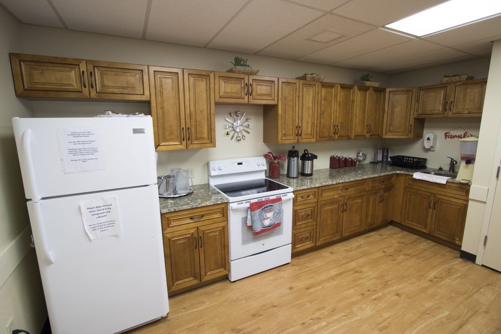 A cozy kitchen with wooden cabinets and modern appliances, including a refrigerator and an oven.