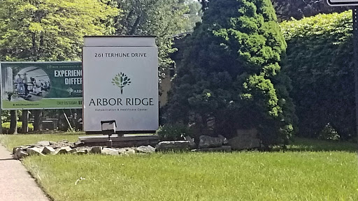 A welcoming sign for Arbor Ridge surrounded by lush greenery.