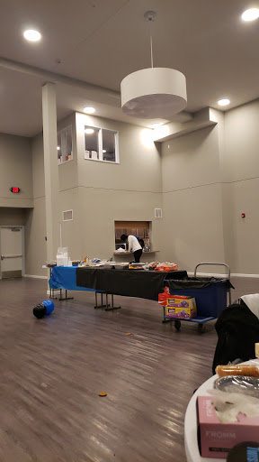 A spacious event room set up for catering, with tables arranged for food preparation.