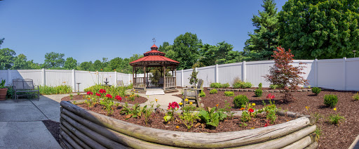 A serene garden featuring a beautiful gazebo surrounded by vibrant flowers and a clear blue sky.