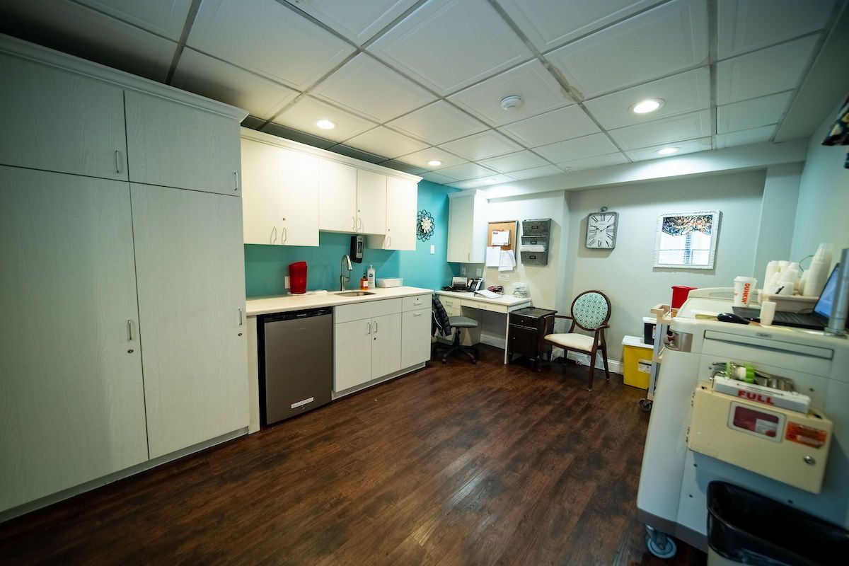 A modern office space with a kitchenette and wooden flooring.