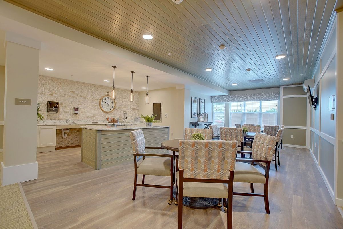 A modern open-layout kitchen and dining area with stylish pendant lights and comfortable seating.