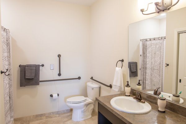 An accessible bathroom with handrails and modern amenities.