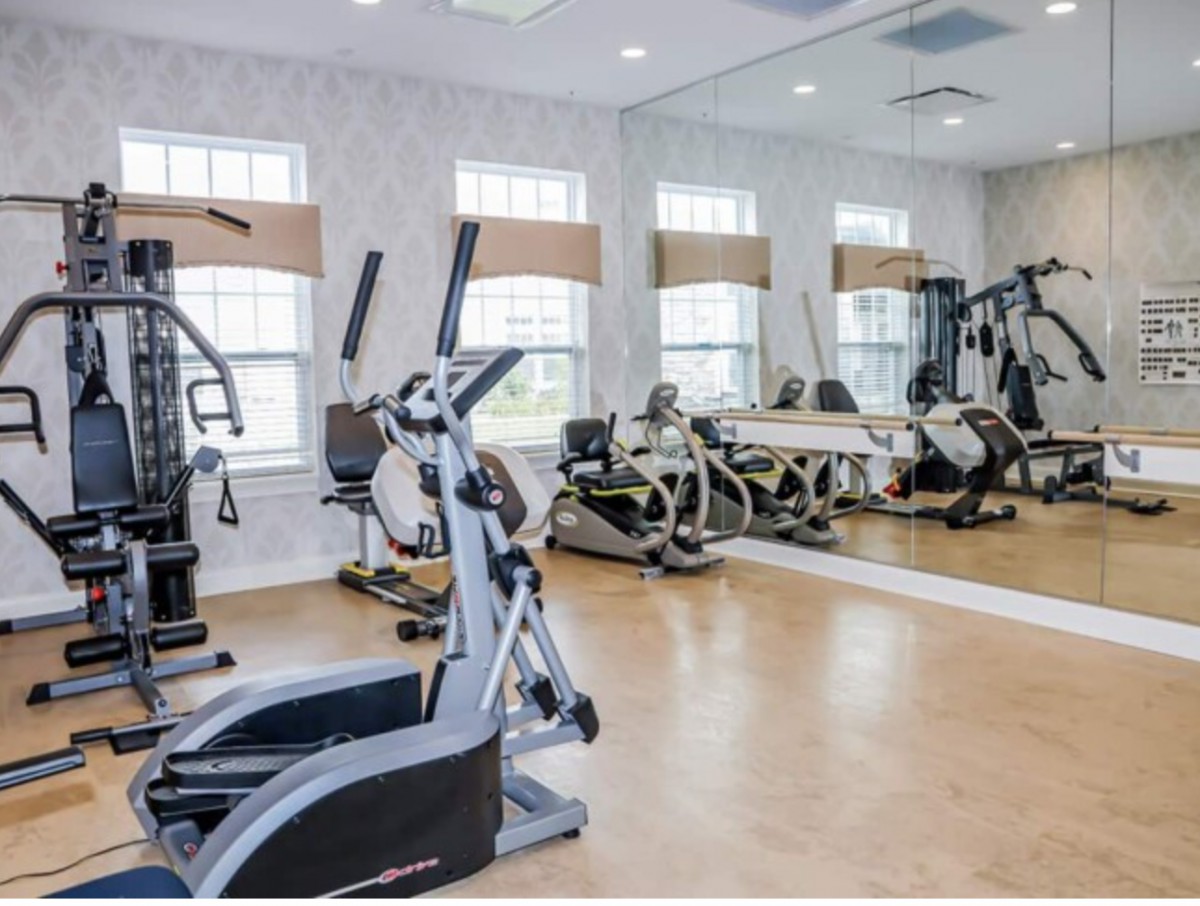 A modern gym with various exercise equipment and cardio machines.