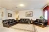 A modern living room with black sofas, a central coffee table, and wall art.