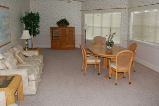 Spacious living and dining area with a sofa, dining table, chairs, and a cabinet.