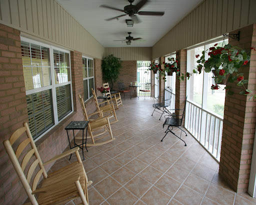 A cozy porch with rocking chairs and ceiling fans, perfect for relaxing outdoors.