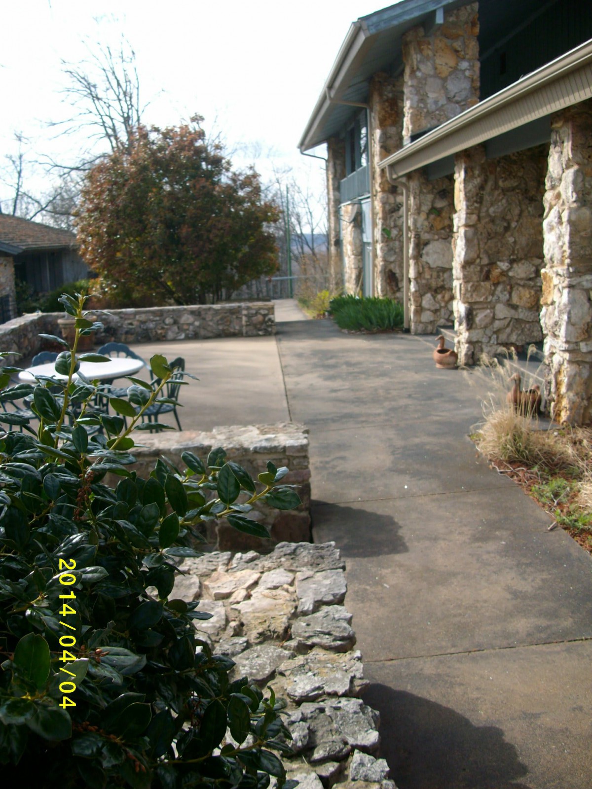 An outdoor patio area with stone walls and furniture alongside a building.