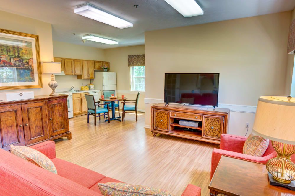 A cozy living space with an open kitchen, featuring a comfortable sofa, television, and dining area.