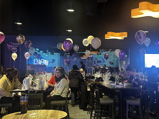A lively indoor dining space decorated with balloons, showcasing a festive atmosphere.