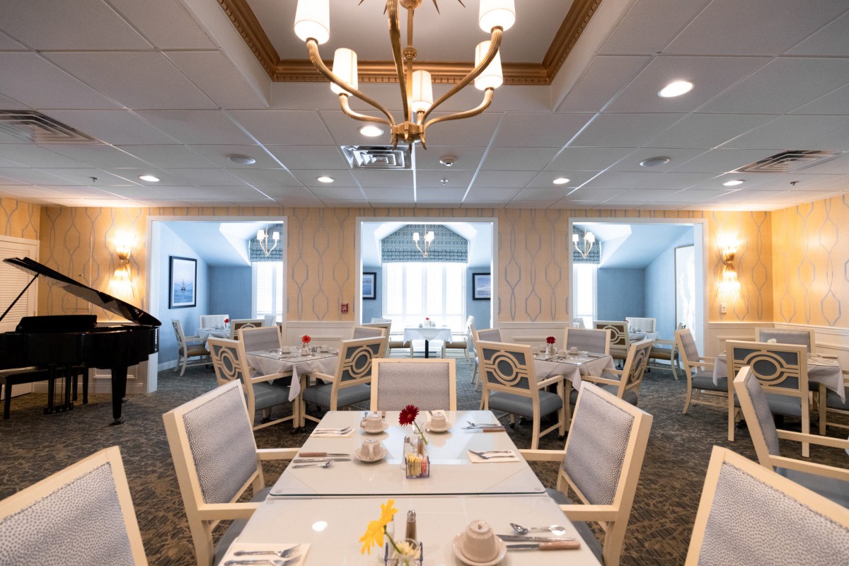 A well-lit, elegant dining room with neatly arranged tables and chairs.