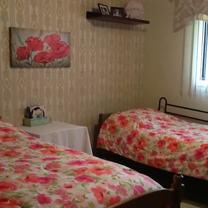 A cozy bedroom with twin beds featuring floral bedspreads and wall decor.