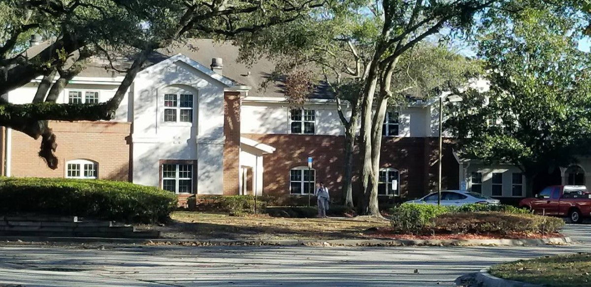 Suburban house with brick facade and trees in the front yard.